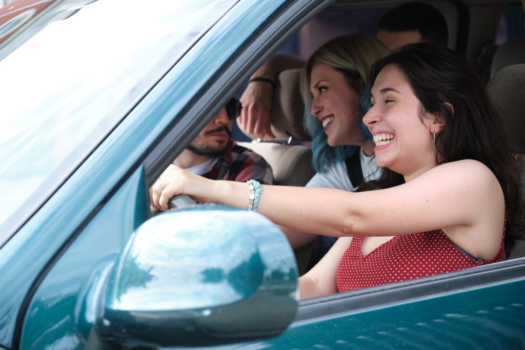 Group of friends travel together driving a car and having fun.